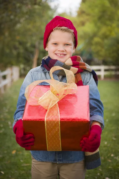 Niño joven con ropa de vacaciones celebración de regalo de Navidad Outsid —  Fotos de Stock