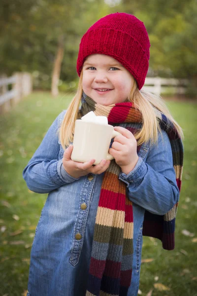 Roztomilá mladá dívka drží kakaa hrnek s marsh mallows mimo — Stock fotografie