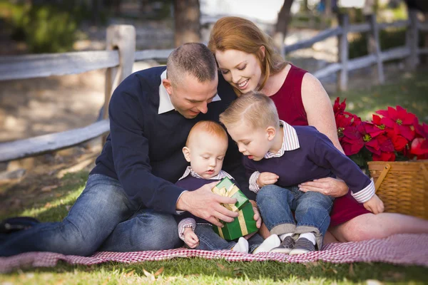 Kleine jonge familie openen de giften van Kerstmis in het park — Stockfoto