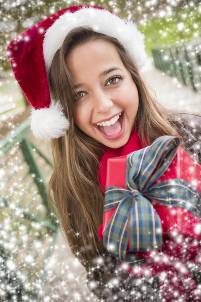 Hezká žena nosí čepice santa s zabalený dárek — Stock fotografie