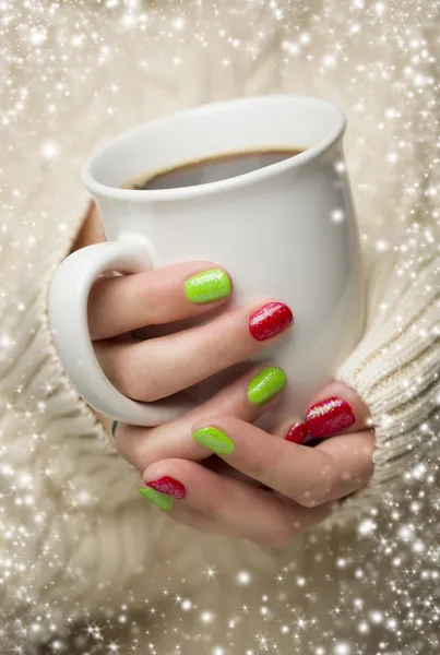 Mulher com unhas vermelhas e verdes polonês segurando xícara de café — Fotografia de Stock