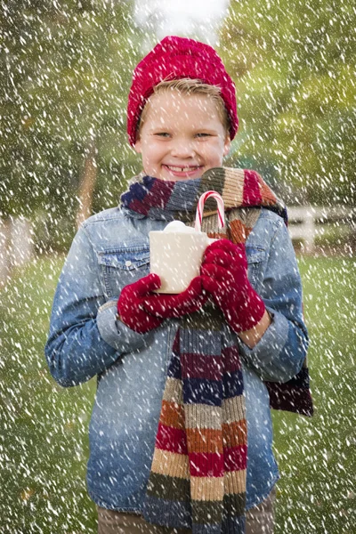 外に熱いココア マグカップを保持している暖かい服装で若い男の子 — ストック写真