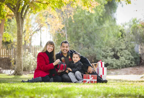 Famille métissée jouissant de cadeaux de Noël dans le parc ensemble — Photo