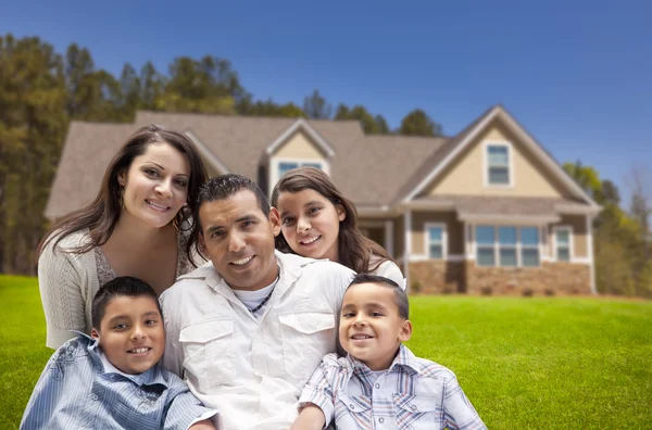 Família hispânica jovem na frente de sua nova casa — Fotografia de Stock