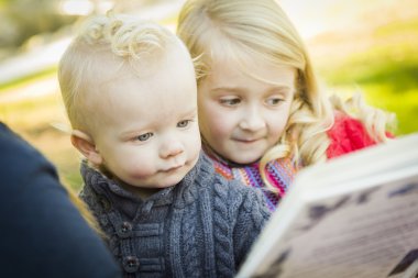 Anne iki sevimli sarışın çocuğu Park için bir kitap okuma