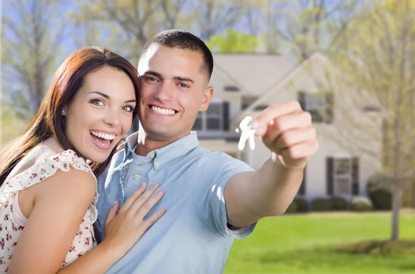 Couple militaire avec clés de la maison devant une nouvelle maison — Photo
