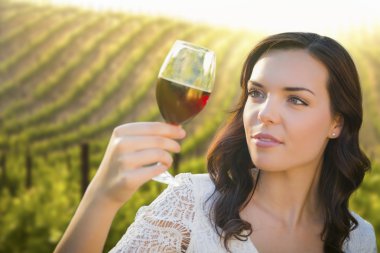 Young Adult Woman Enjoying A Glass of Wine in Vineyard clipart