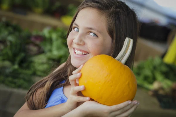 Vrij jong meisje met plezier met de pompoenen in de markt — Stockfoto