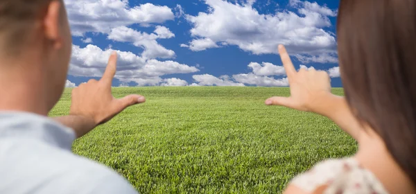 Paar framing handen rond ruimte in grasveld — Stockfoto