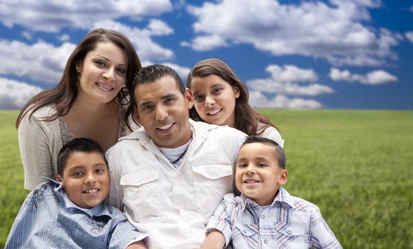 Retrato familiar hispano sentado en el campo de hierba — Foto de Stock