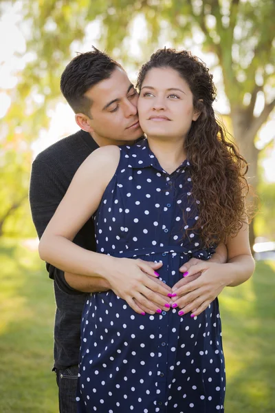 Hispanique homme étreint sa femme enceinte en plein air au parc — Photo