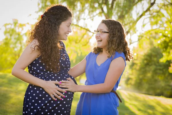 西班牙裔美国人的女儿感觉踢在孕妈妈的肚子里的宝宝 — 图库照片