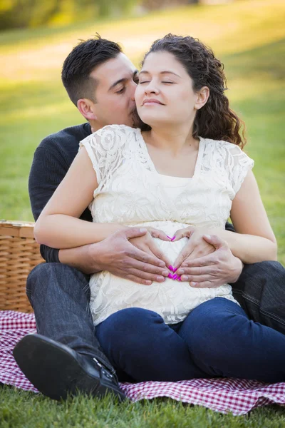 Casal hispânico grávida fazendo forma de coração com as mãos na barriga — Fotografia de Stock