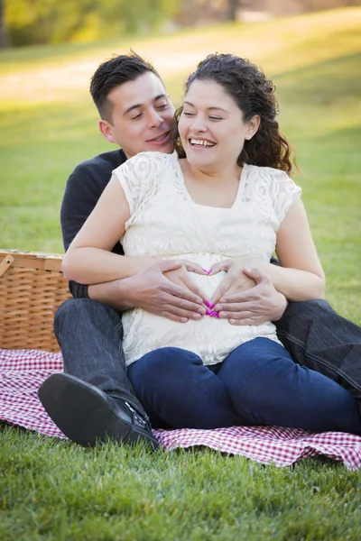 Embarazada pareja hispana haciendo forma de corazón con las manos en el vientre —  Fotos de Stock