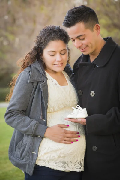 西班牙裔美国人怀孕的夫妇牵着婴儿鞋外 — 图库照片