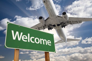 Welcome Green Road Sign and Airplane Above clipart