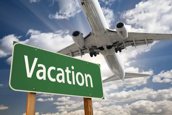 Vakantie groene verkeersbord en vliegtuig hierboven — Stockfoto