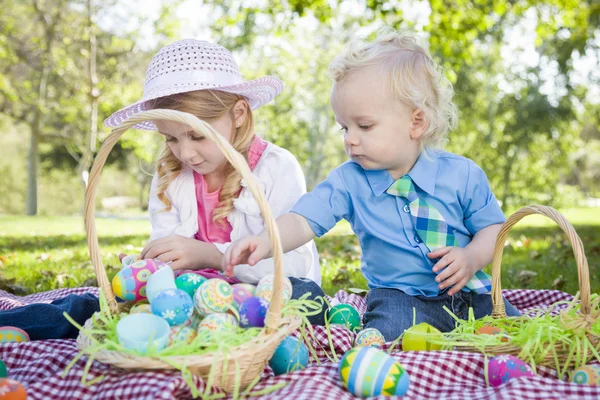 Söt ung bror och syster njuter sina påskägg utanför — Stockfoto