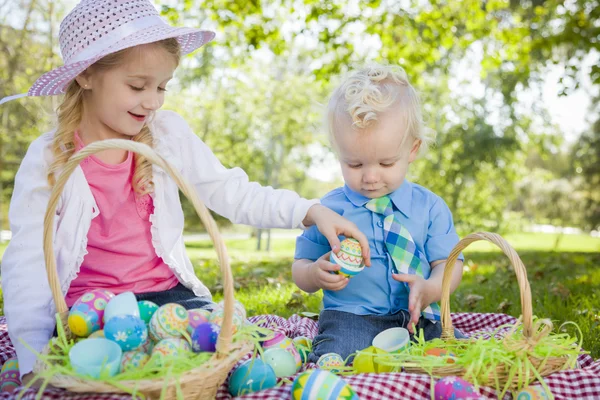 Lindo joven hermano y hermana disfrutando su Pascua huevos fuera — Foto de Stock