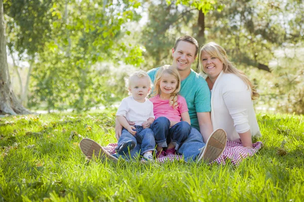 Unga attraktiva familjeporträtt i parken — Stockfoto