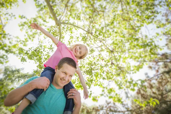 Niedliche junge Mädchen reitet huckepack auf ihren Papas Schultern — Stockfoto