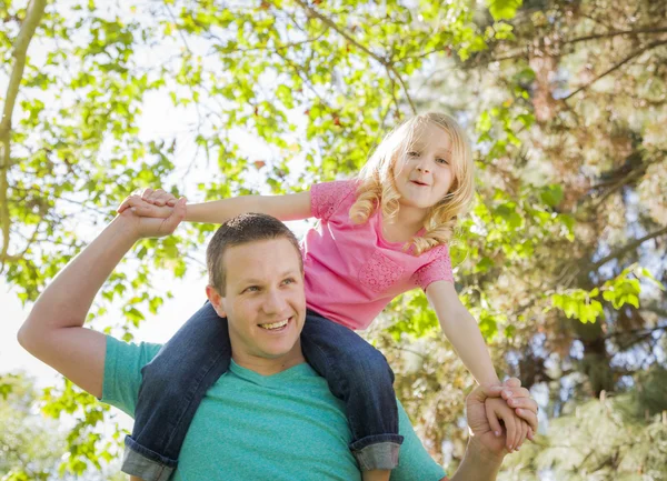 Niedliche junge Mädchen reitet huckepack auf ihren Papas Schultern — Stockfoto