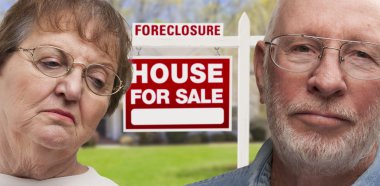 Depressed Senior Couple in Front of Foreclosure Sign and House clipart