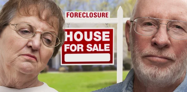 Depressed Senior Couple in Front of Foreclosure Sign and House — Stock Photo, Image