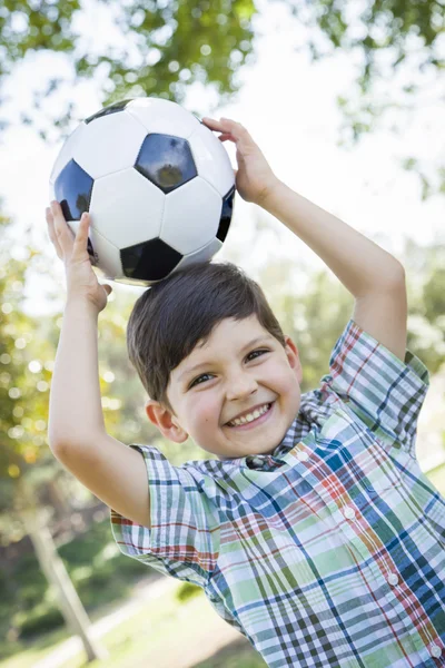 Roztomilý mladý chlapec hraje s fotbalovým míčem v parku — Stock fotografie