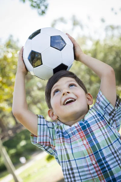 Ładny chłopiec gra z piłki nożnej w parku — Zdjęcie stockowe