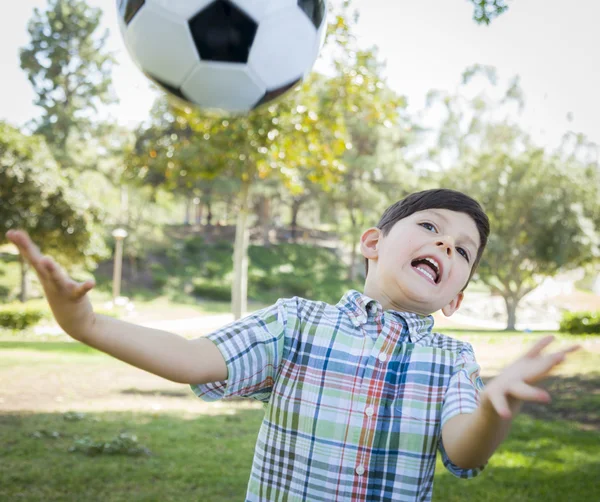 Söt ung pojke leker med fotboll i parken — Stockfoto