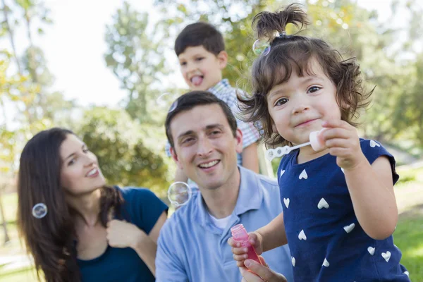 Schattige jonge babymeisje waait bellen met familie in park — Stockfoto