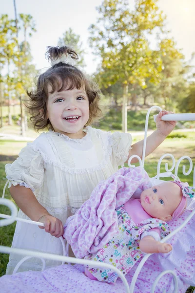 Entzückendes junges Mädchen spielt mit Puppe und Kinderwagen — Stockfoto