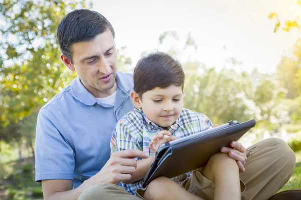 Bello misto razza padre e figlio giocare su computer tablet — Foto Stock