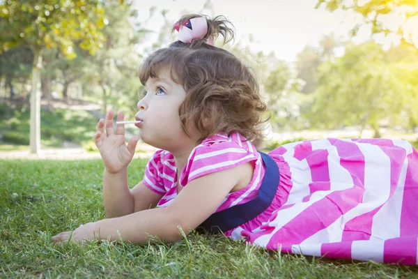 Schattige babymeisje genieten van lollipop buitenleven — Stockfoto