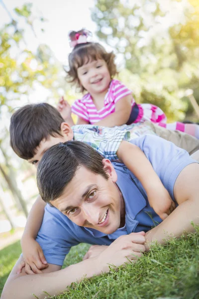 Joven hijo e hija divirtiéndose con su padre al aire libre — Foto de Stock