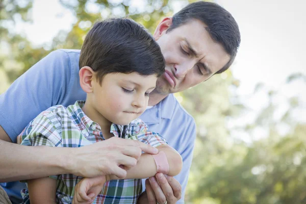 Kochający ojciec stawia bandaż na łokieć synka — Zdjęcie stockowe