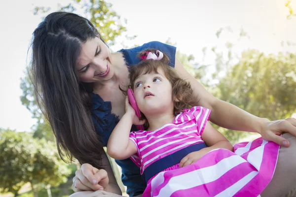 Madre e carina bambina che gioca con il telefono cellulare — Foto Stock