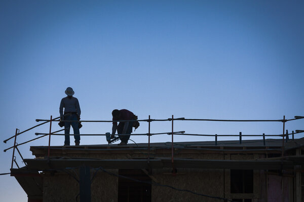 Construction Workers Silhouette on Roof