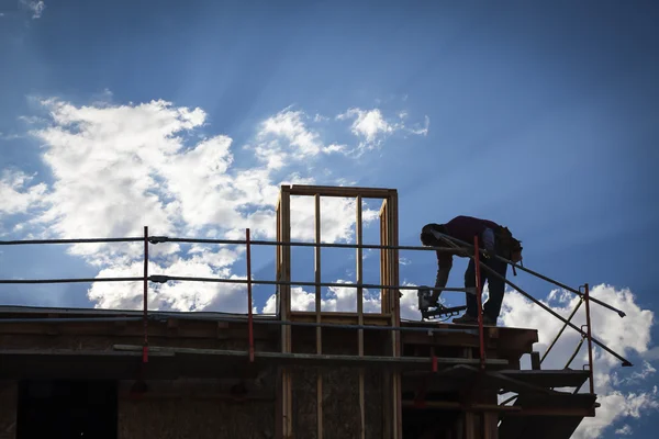 Silhueta de trabalhador de construção no telhado — Fotografia de Stock
