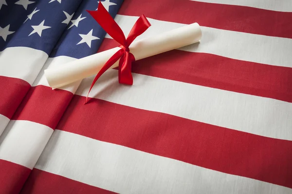 Ribbon Wrapped Diploma Resting on American Flag with Copy Space — Stock Photo, Image