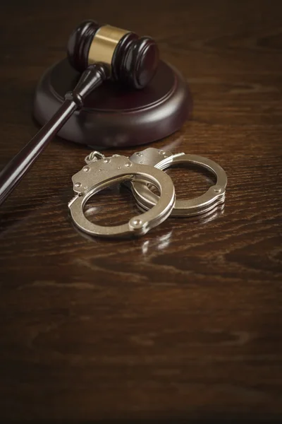 Hamer en paar handboeien op tafel — Stockfoto