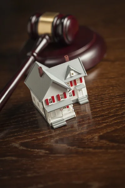 Gavel e pequena casa modelo na mesa — Fotografia de Stock