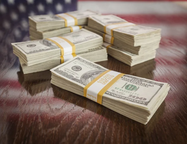 Milhares de dólares com reflexo da bandeira americana na mesa — Fotografia de Stock