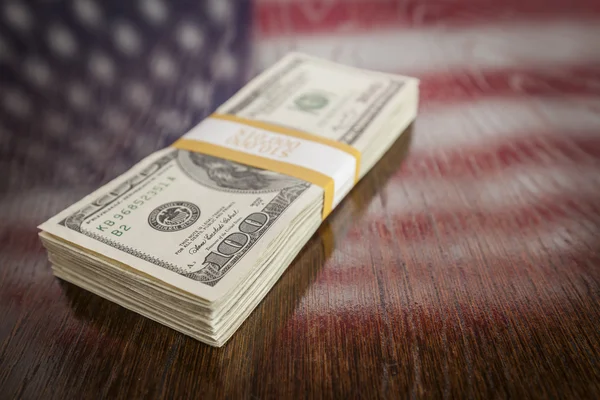 Milhares de dólares com reflexo da bandeira americana na mesa — Fotografia de Stock