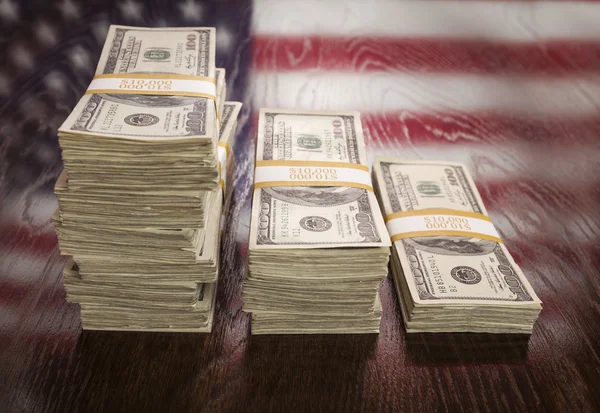 Тисячі доларів з відображенням американським прапором на стіл — стокове фото