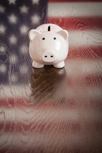 Piggy bank met een Amerikaanse vlag reflectie op tafel — Stockfoto