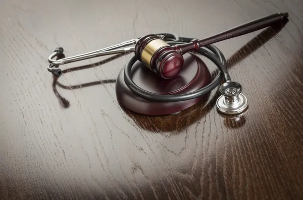 Gavel and Stethoscope on Reflective Table — Stock Photo, Image