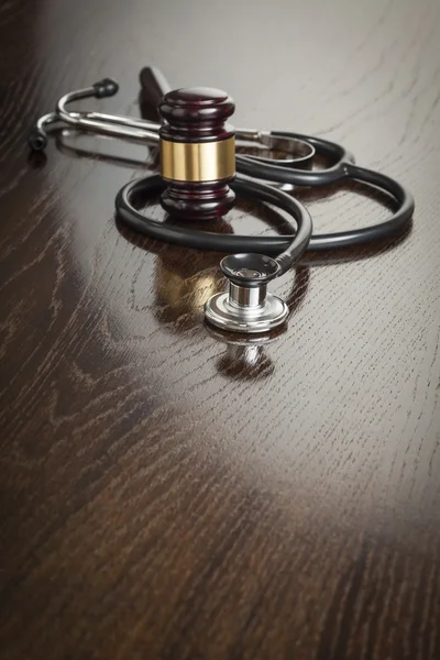 Gavel e estetoscópio na mesa reflexiva — Fotografia de Stock