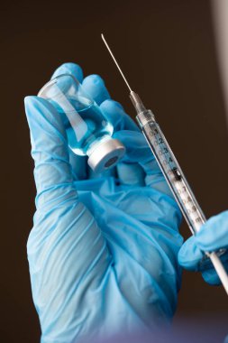 Doktor ya da Hemşire Cerrahi Eldiven Giyen Aşı Şişesi ve Şırınga.